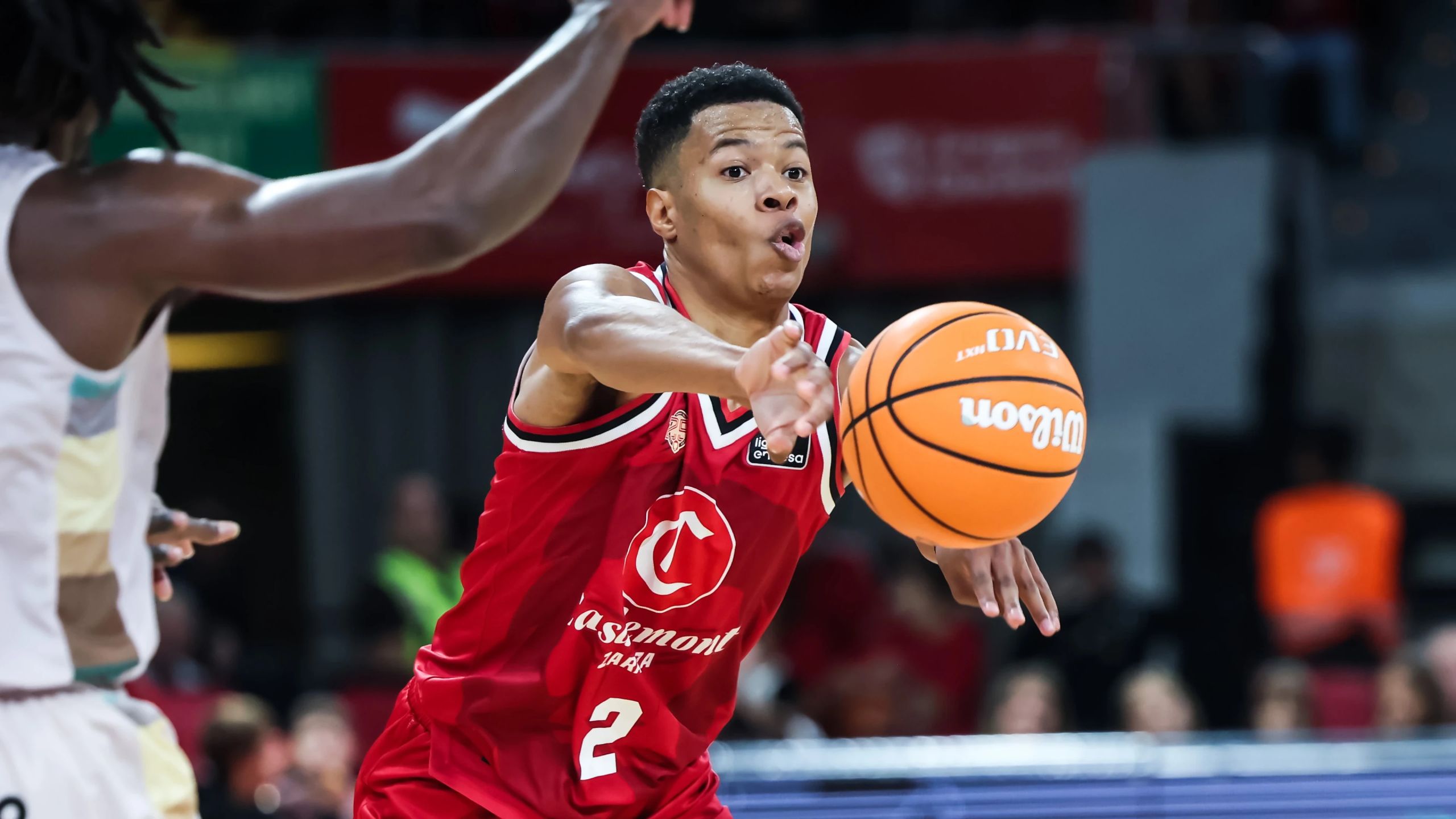 Trae Bell-Haynes, con el dorsal 2 del Casademont Zaragoza, da un pase ante el iLERNA Lleida