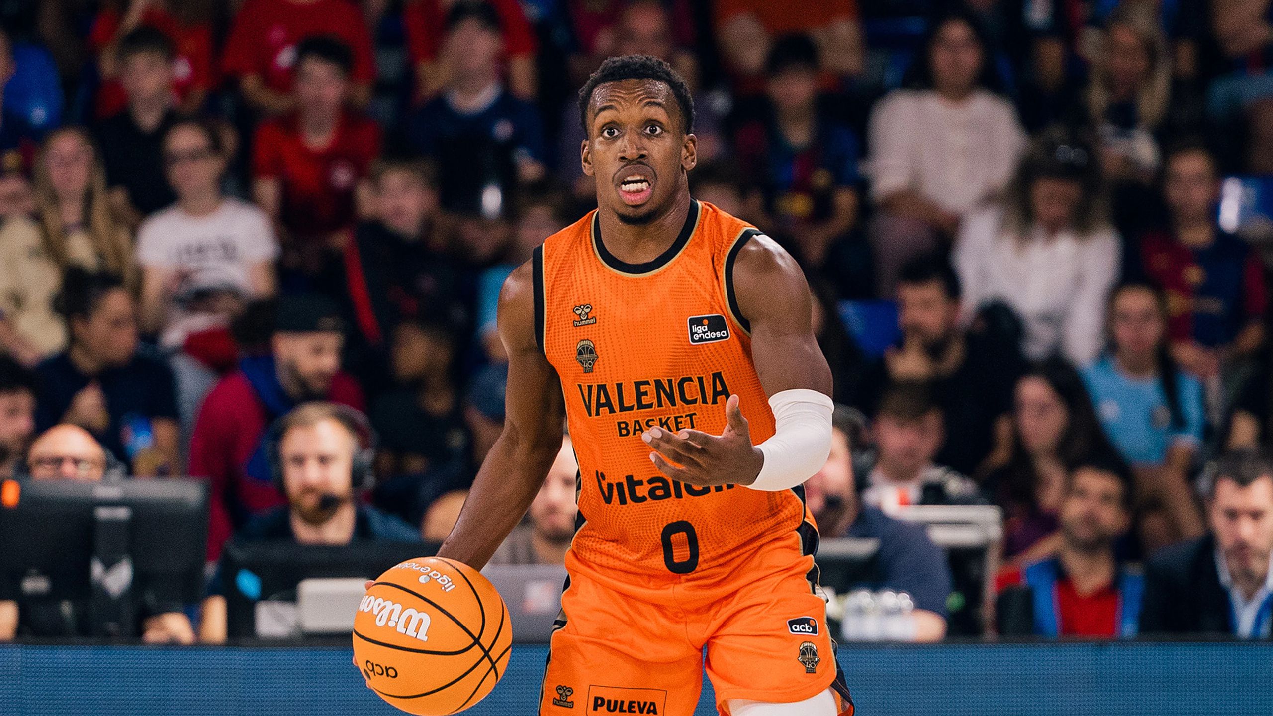 TJ Shorts, con el 0 del Valencia Basket y camiseta naranja, sube el balón botando en el Palau Blaugrana durante el Barça-Valencia de la Liga Endesa del 11 de octubre de 2026