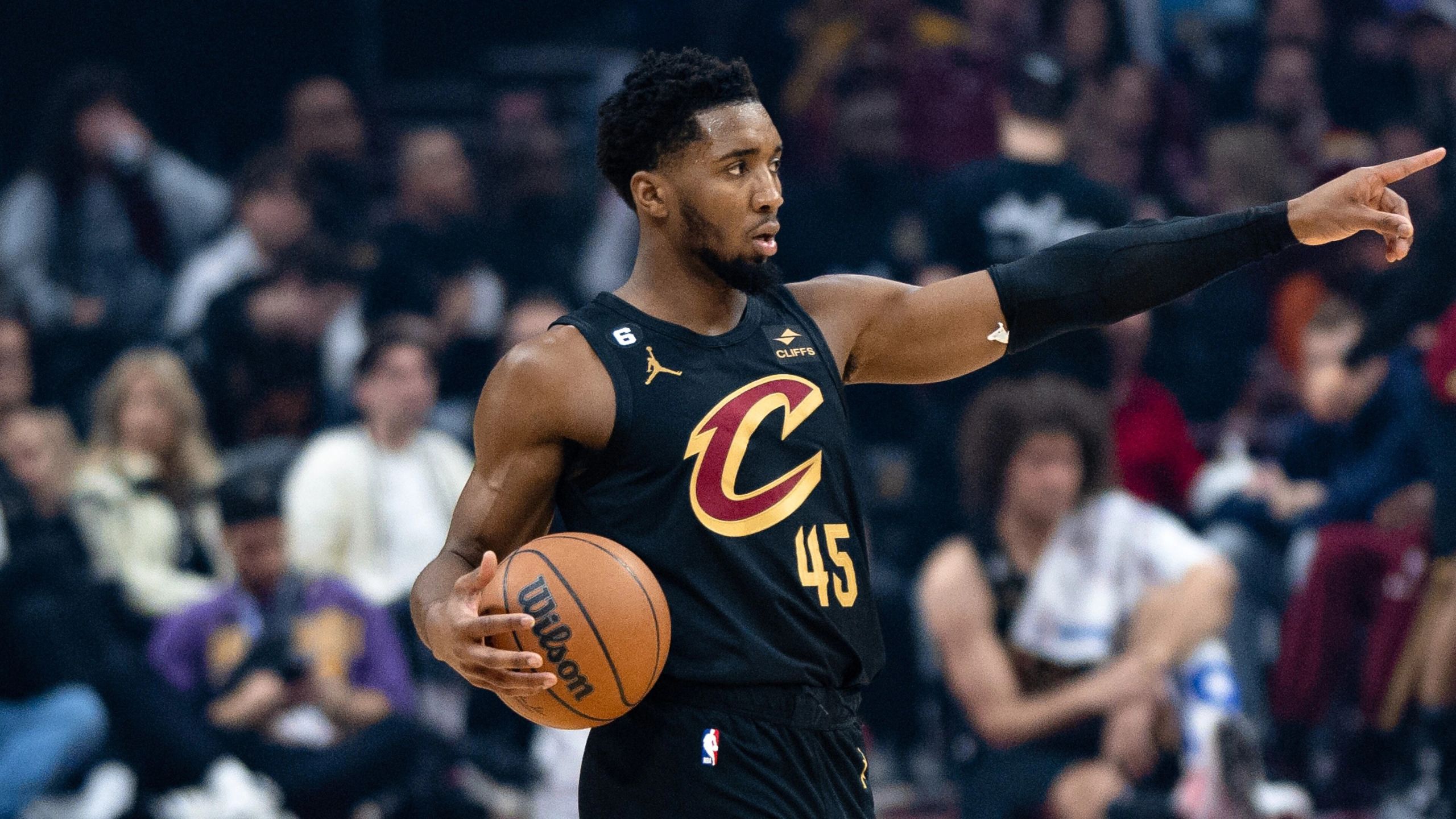 Donovan Mitchell, con la camiseta de los Cleveland Cavaliers, da indicaciones con el balón en la mano
