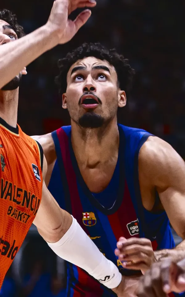 Justin Minaya pelea por el rebote ante dos jugadores del Valencia Basket en la Supercopa Endesa