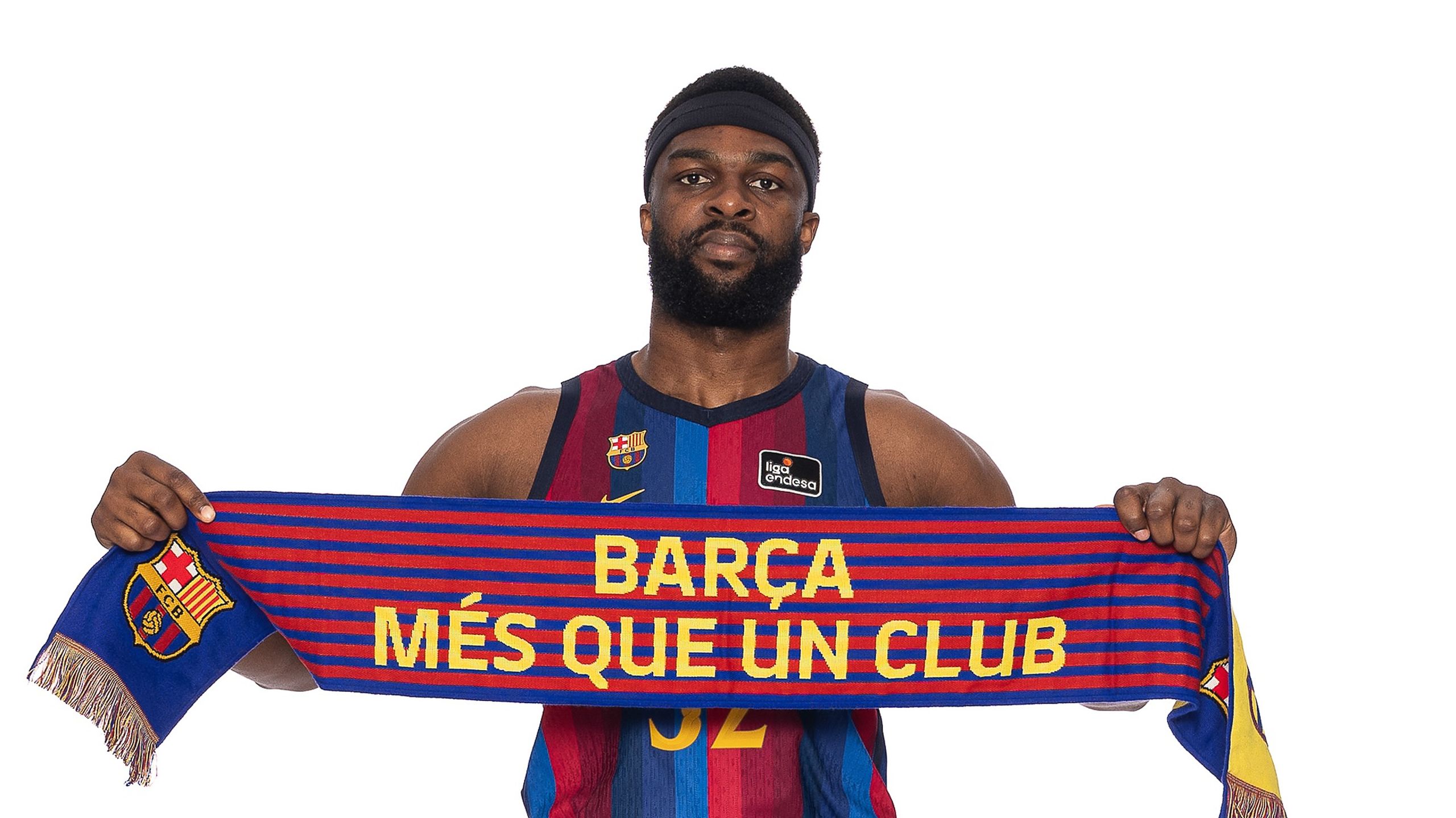 Josh Nebo, pívot del Barça con el dorsal 32, sostiene una bufanda azulgrana con el lema «Més que un club» en la sesión de fotos oficial de la Liga Endesa