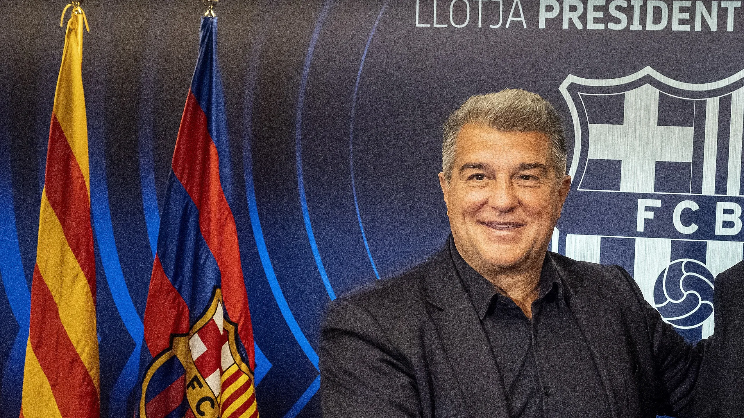 Joan Laporta, presidente del FC Barcelona, sonriente ante el escudo del club en el palco del Camp Nou