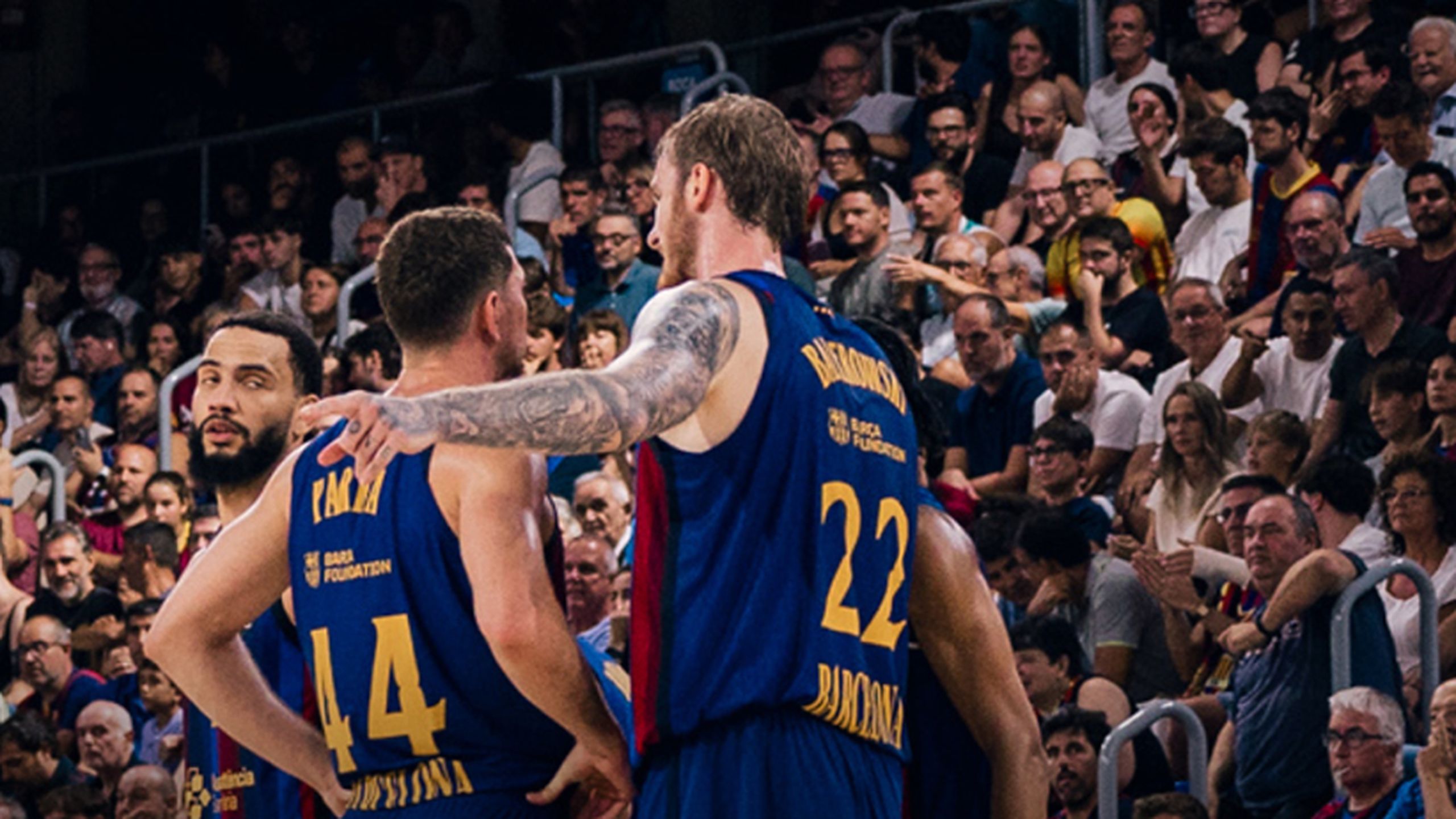 Jugadores del Barça, con los dorsales 44 y 22, se abrazan ante la grada llena del Palau Blaugrana
