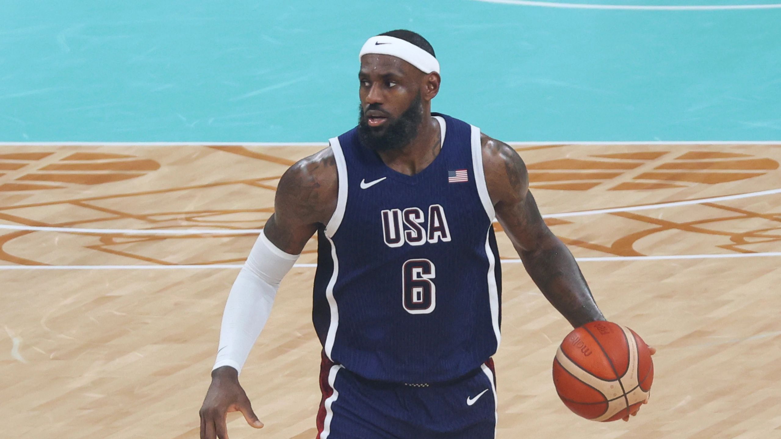 LeBron James, con la camiseta de Estados Unidos en los Juegos Olímpicos de París 2024, bota el balón (foto de agosto de 2024, antes de fichar por los Sixers)