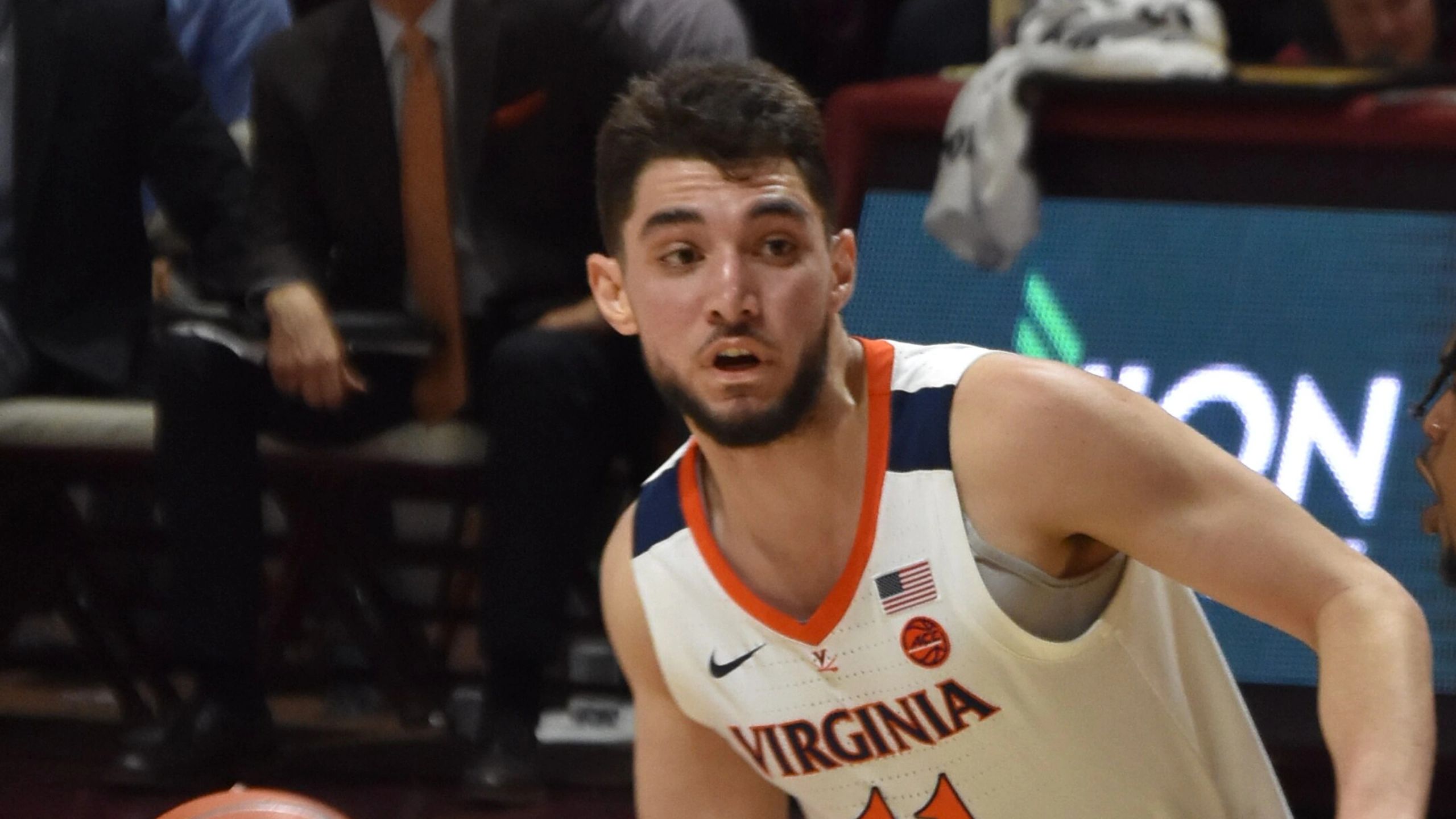 Ty Jerome, con la camiseta de la Universidad de Virginia y el dorsal 11, bota el balón ante Virginia Tech en febrero de 2019, antes de llegar a la NBA